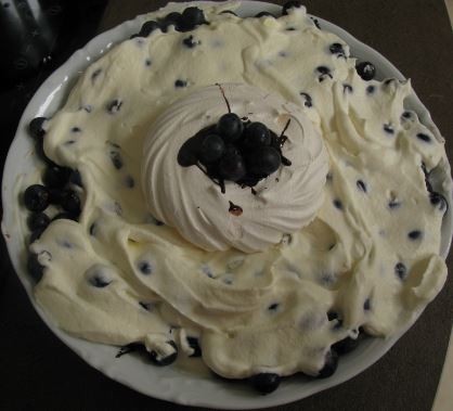 A komponerade skolavslutningstårtan själv. I botten ligger krossade maränger, täckta av ett lager smält 70%-ig choklad. Sen blåbär, grädde och överst en stor maräng till prydnad med mer smält choklad. Mums!