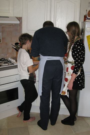 J och barnen bygger pepparkakshuset under stor koncentration.