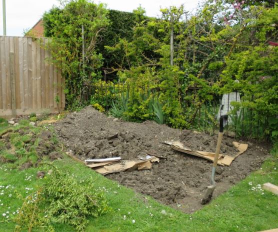 När träd och buskar var i jorden började jag gräva upp gräsmattan för att göra ett grönsaksland. För att göra leran lite roligare för växterna så har jag grävt ner en massa kvistar, ogräs och flyttkartonger. Det kommer maskarna gilla och när det gått genom maskarna blir det smaskig jord för växterna.