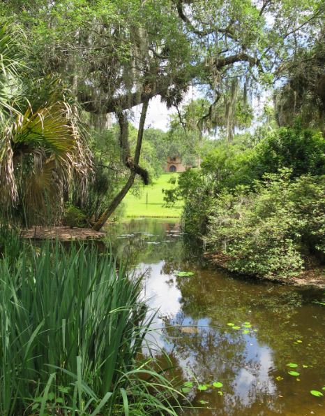 Från dammen längst ner i den mer välordnade trädgården kunde man skymta huset. 